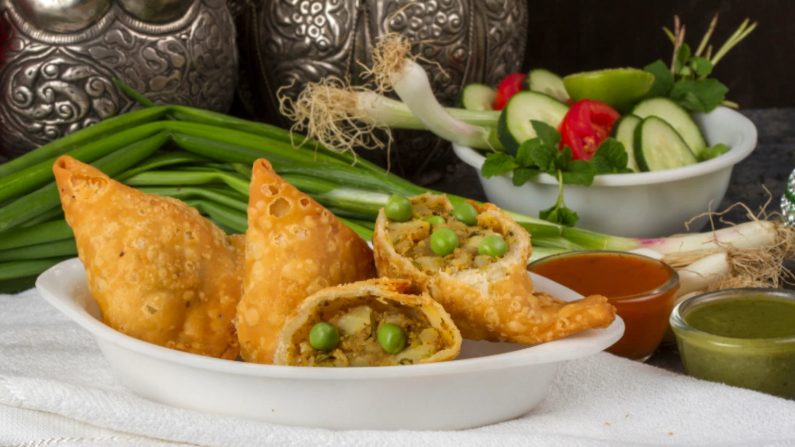 Close-up of a golden, crispy samosa with visible potato filling; a nutritional guide from Ace Blend. 